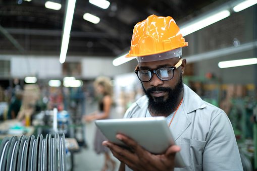 Engineer using tablet and working in factory